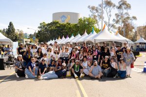 Alumni group chapter members pose in front of the tents and Anteater water tower