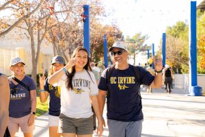 An alumni couple uses their hands to zot