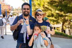 An alumni couple zots with child