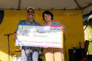 Executive Director Derek Sabori receives a large check
