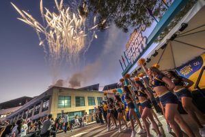 Fireworks take off above the buildings and cheerleaders